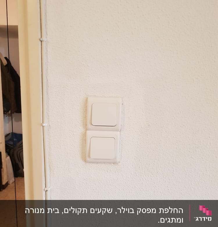שני מתגי חשמל על קיר לבן